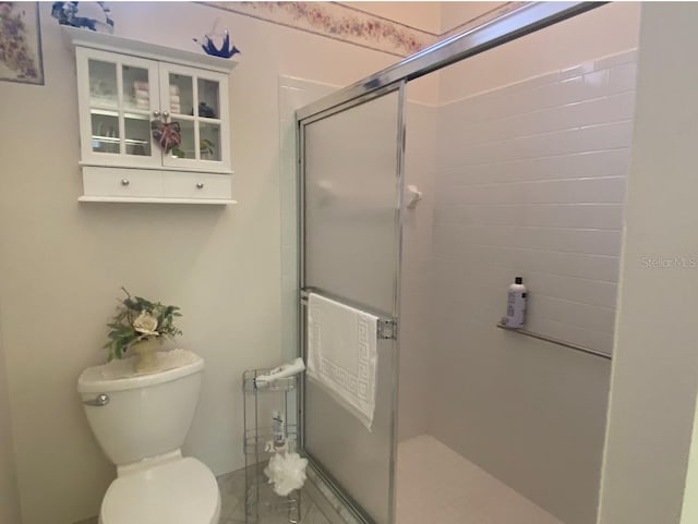 bathroom featuring toilet and an enclosed shower