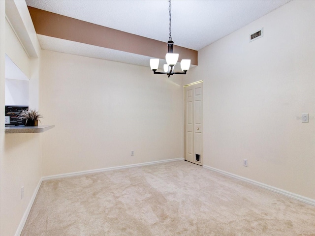 empty room featuring carpet floors and a notable chandelier