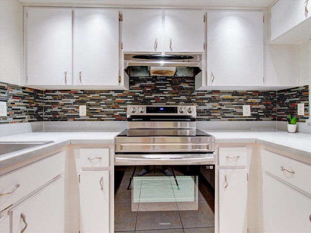 kitchen featuring white cabinets, tile patterned flooring, tasteful backsplash, and stainless steel electric range oven