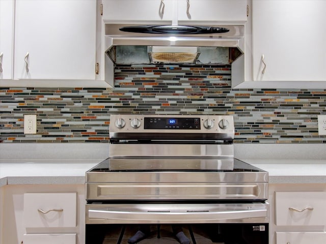 kitchen with stainless steel electric range oven, tasteful backsplash, and white cabinets