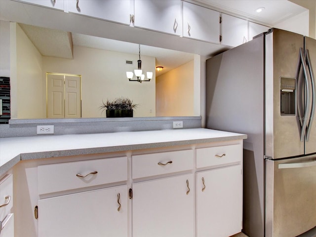 kitchen with hanging light fixtures, stainless steel refrigerator with ice dispenser, white cabinets, and a chandelier