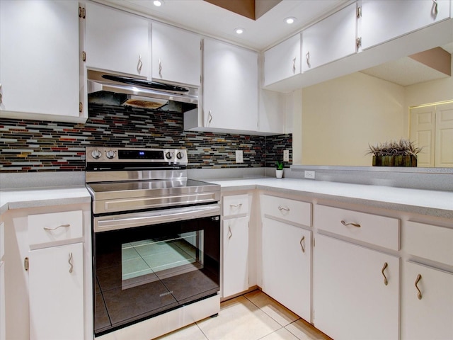 kitchen featuring light tile patterned floors, decorative backsplash, stainless steel electric range oven, white cabinetry, and range hood