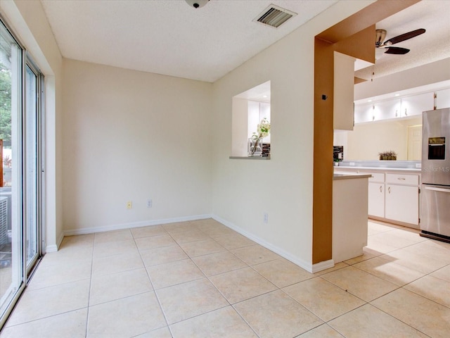 kitchen with white cabinets, stainless steel refrigerator with ice dispenser, light tile patterned floors, and ceiling fan