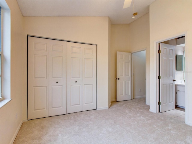 unfurnished bedroom with lofted ceiling, light carpet, ensuite bath, and ceiling fan