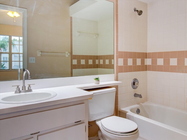 full bathroom with toilet, vanity, and tiled shower / bath