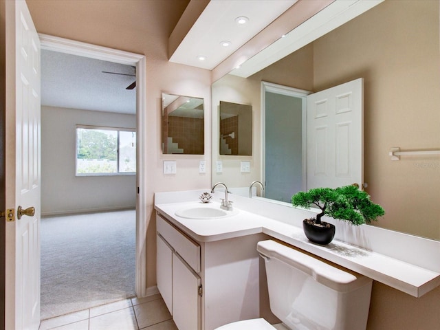 bathroom with tile patterned floors, vanity, a textured ceiling, and toilet