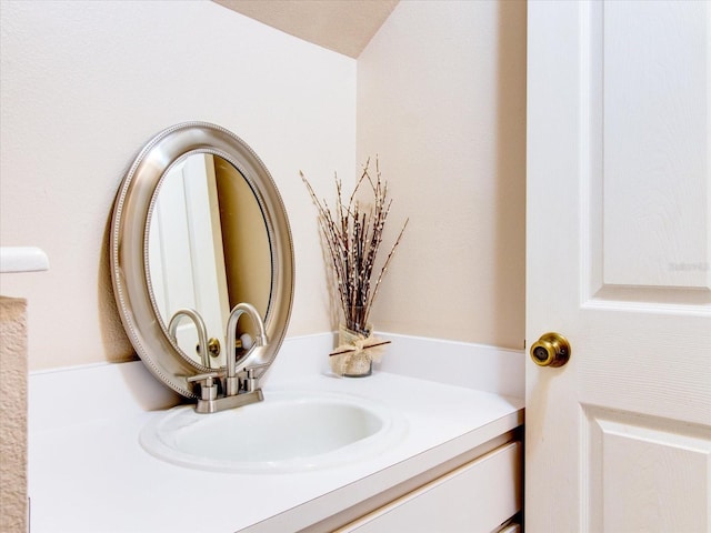 bathroom with lofted ceiling and vanity