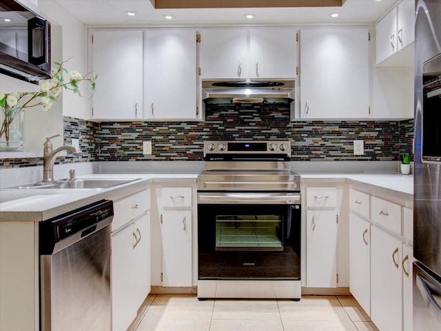 kitchen with tasteful backsplash, white cabinets, range hood, stainless steel appliances, and sink