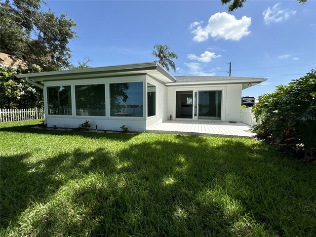 rear view of property featuring a lawn