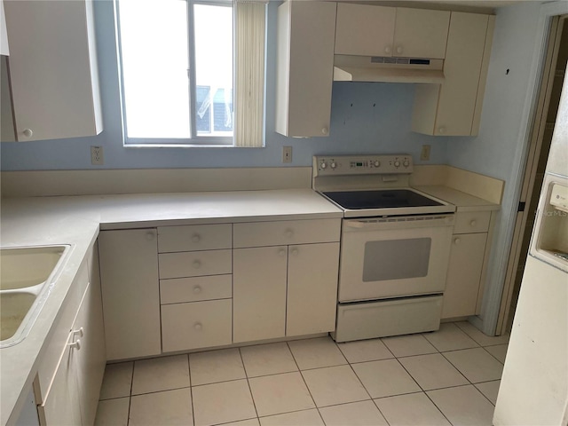 kitchen featuring light tile patterned flooring, sink, electric stove, and fridge