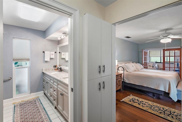 bedroom featuring ceiling fan, sink, a closet, and light hardwood / wood-style floors