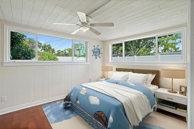 bedroom with ceiling fan, multiple windows, hardwood / wood-style flooring, and wood ceiling