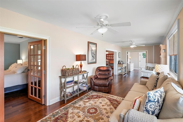 living room featuring ceiling fan and dark wood-type flooring