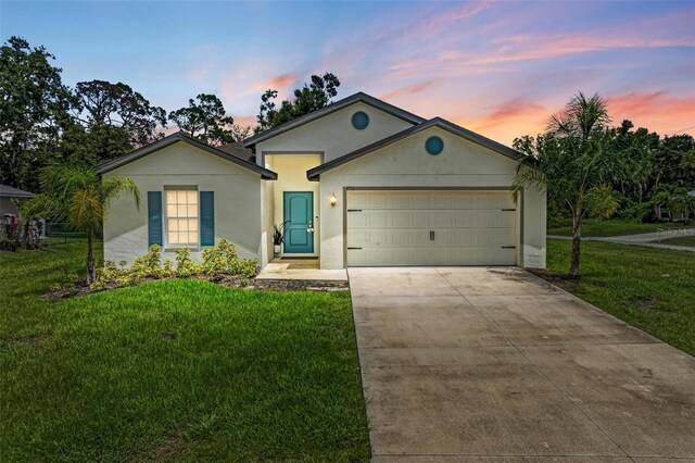 single story home with a garage and a yard