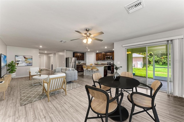 dining area with ceiling fan and light hardwood / wood-style flooring