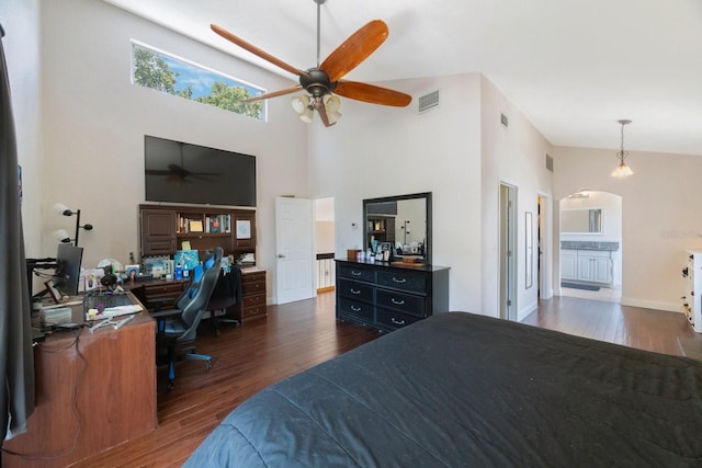 bedroom featuring ceiling fan, a towering ceiling, dark hardwood / wood-style flooring, and ensuite bath