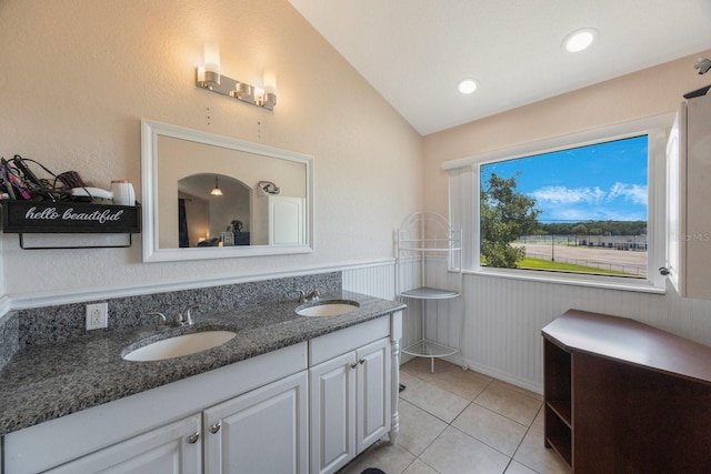 bathroom with lofted ceiling, vanity, and tile patterned floors