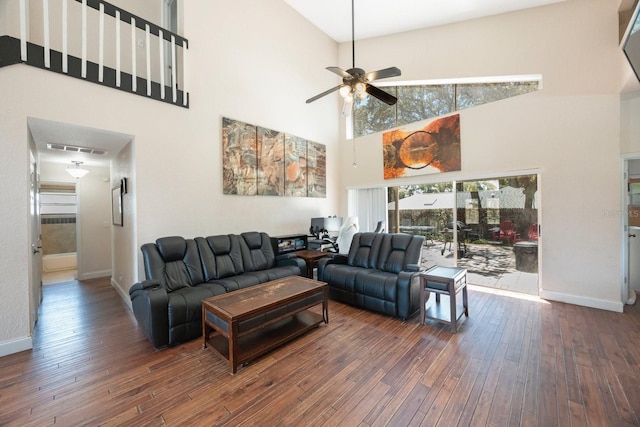 living room with a high ceiling, ceiling fan, and dark hardwood / wood-style flooring