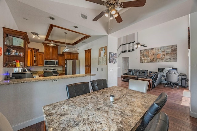 dining room featuring ceiling fan, dark hardwood / wood-style floors, a raised ceiling, and sink