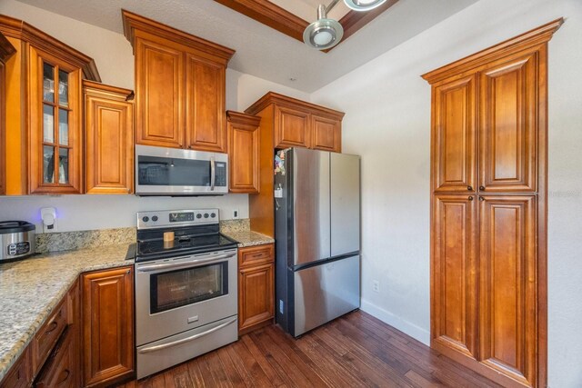 kitchen featuring stainless steel appliances, dark hardwood / wood-style flooring, and light stone countertops