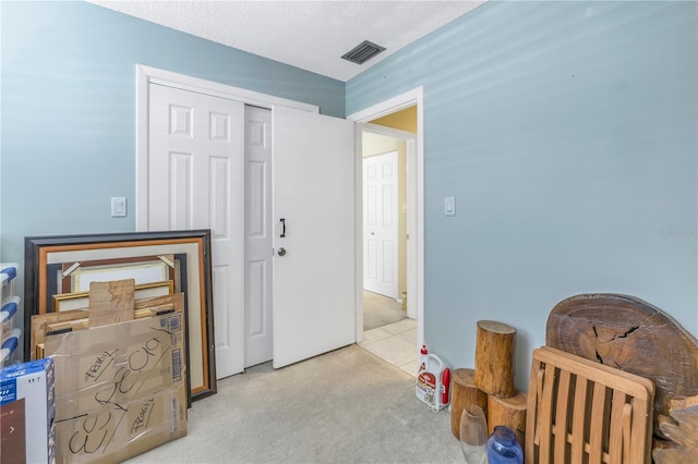 carpeted bedroom with a textured ceiling and a closet