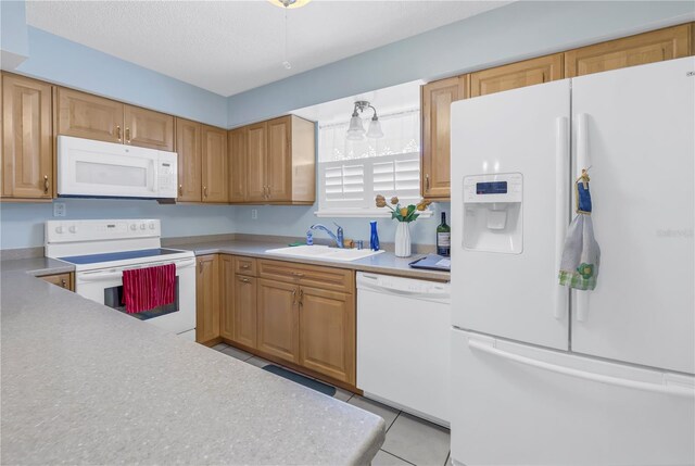 kitchen featuring a textured ceiling, white appliances, sink, and light tile patterned floors