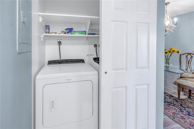 washroom with separate washer and dryer, electric panel, and an inviting chandelier