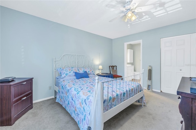 bedroom featuring ceiling fan, ensuite bathroom, and light colored carpet