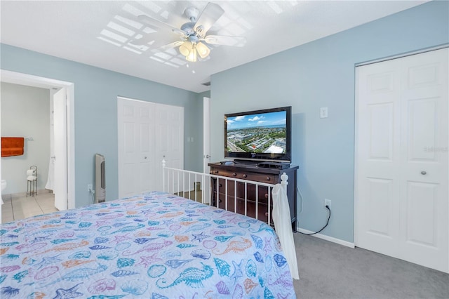 bedroom with light carpet, ensuite bath, and ceiling fan