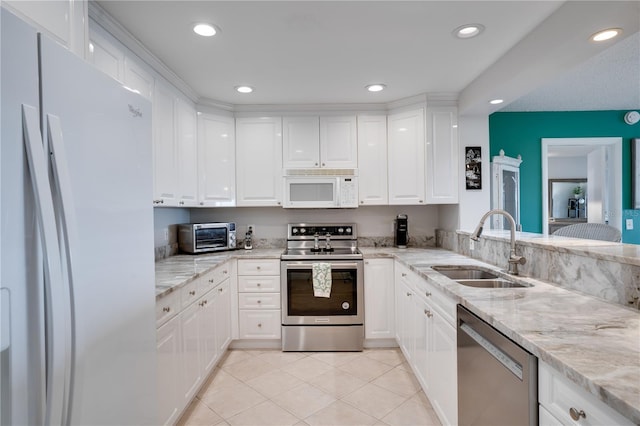 kitchen with white cabinets, sink, light stone counters, and stainless steel appliances