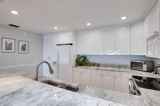 kitchen featuring light stone countertops, sink, white cabinetry, and white appliances