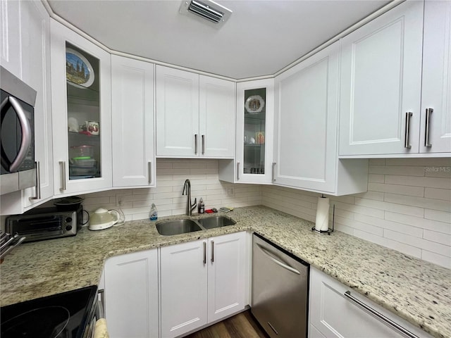 kitchen featuring tasteful backsplash, white cabinets, sink, appliances with stainless steel finishes, and dark wood-type flooring