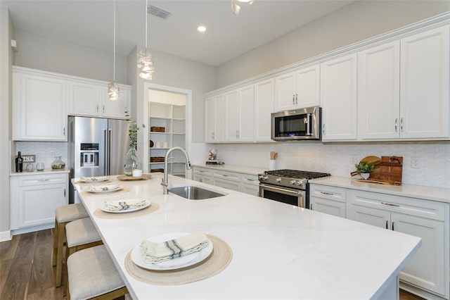 kitchen with tasteful backsplash, sink, stainless steel appliances, and white cabinetry