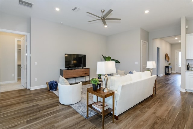 living room with ceiling fan and dark hardwood / wood-style flooring