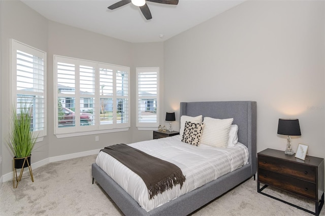 bedroom with ceiling fan, multiple windows, and light carpet