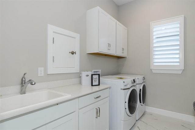 clothes washing area featuring cabinets, washer and dryer, and sink