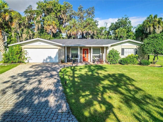 ranch-style house with a garage and a front lawn