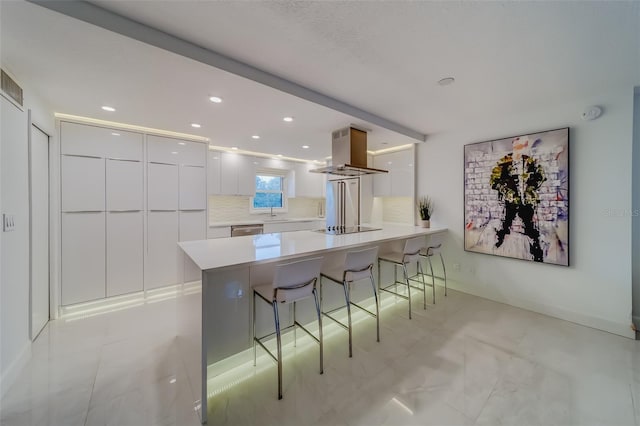 kitchen with tasteful backsplash, island range hood, white cabinetry, dishwasher, and black electric cooktop