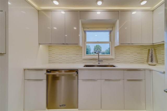 kitchen featuring sink, tasteful backsplash, white cabinetry, and dishwasher