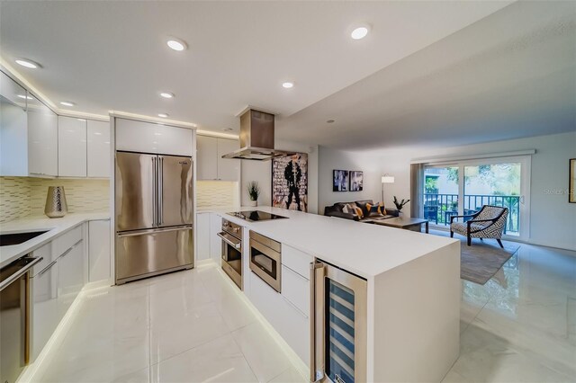 kitchen with beverage cooler, decorative backsplash, light tile patterned floors, built in appliances, and island exhaust hood