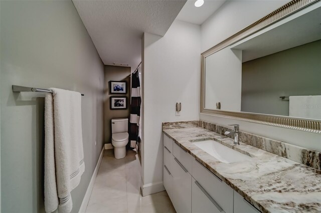 bathroom featuring tile patterned floors, vanity, and toilet