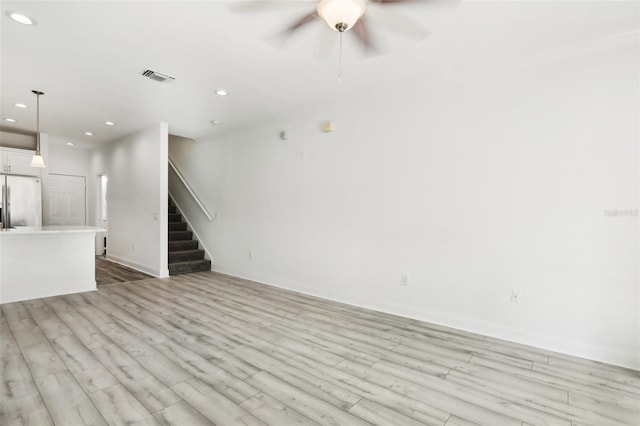 unfurnished living room with recessed lighting, visible vents, light wood-style floors, a ceiling fan, and stairs