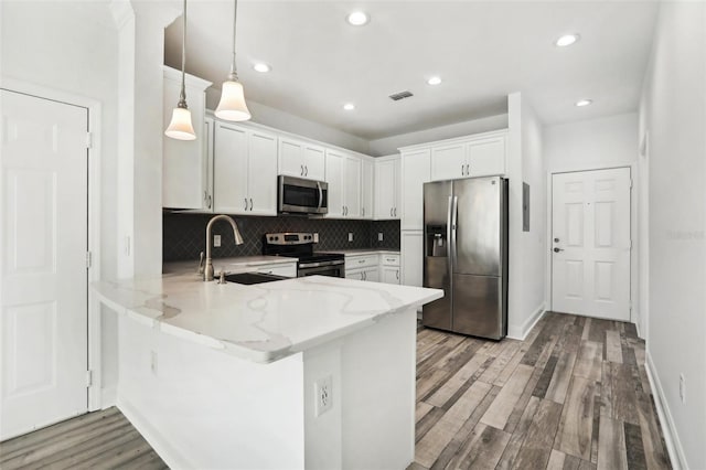 kitchen featuring pendant lighting, sink, white cabinetry, and stainless steel appliances