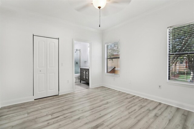 unfurnished bedroom with light wood-type flooring, ornamental molding, ceiling fan, and ensuite bathroom