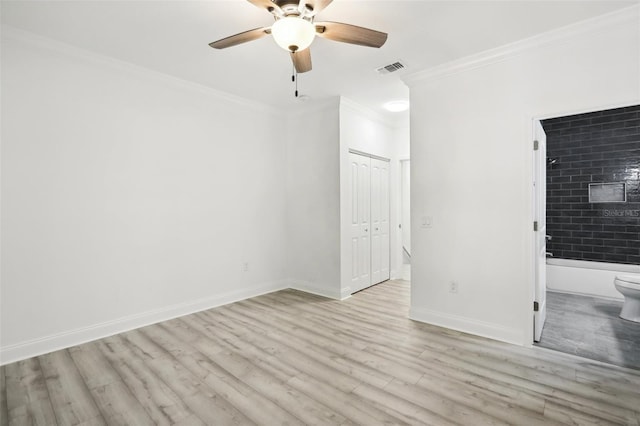 unfurnished bedroom with connected bathroom, wood finished floors, visible vents, baseboards, and ornamental molding