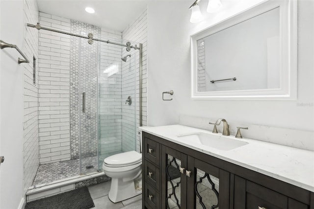 bathroom with walk in shower, vanity, tile patterned floors, and toilet