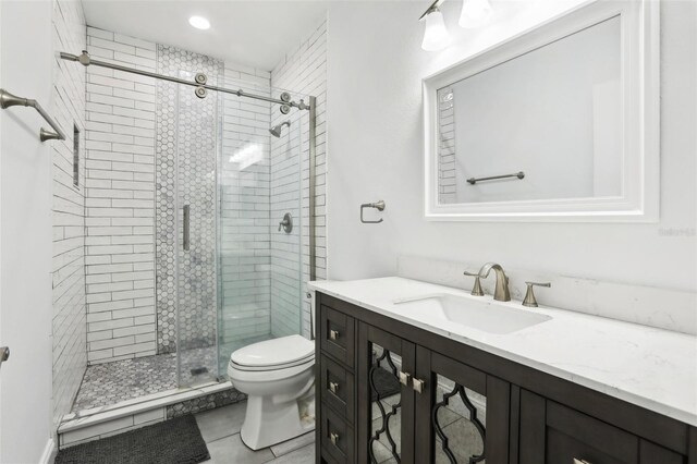 full bathroom featuring toilet, a stall shower, vanity, and tile patterned flooring