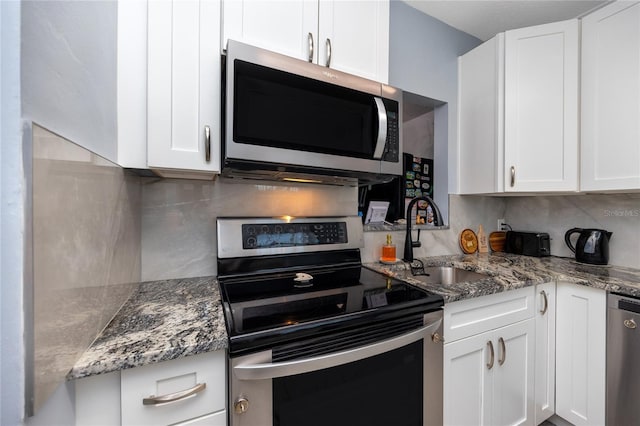 kitchen with white cabinetry, backsplash, appliances with stainless steel finishes, stone countertops, and sink