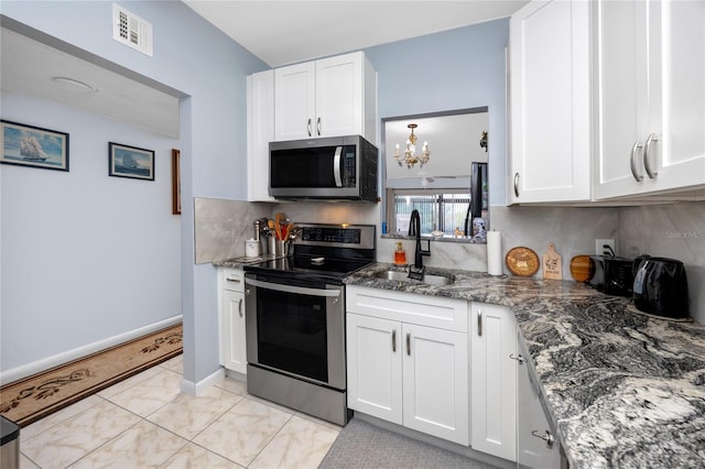 kitchen featuring white cabinetry, tasteful backsplash, light tile patterned floors, appliances with stainless steel finishes, and sink