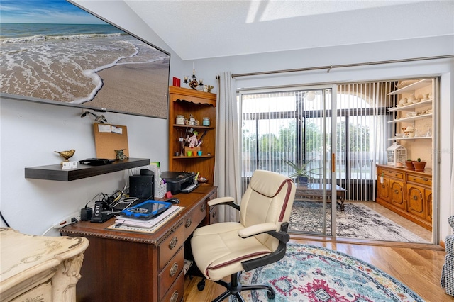 home office with hardwood / wood-style floors and vaulted ceiling